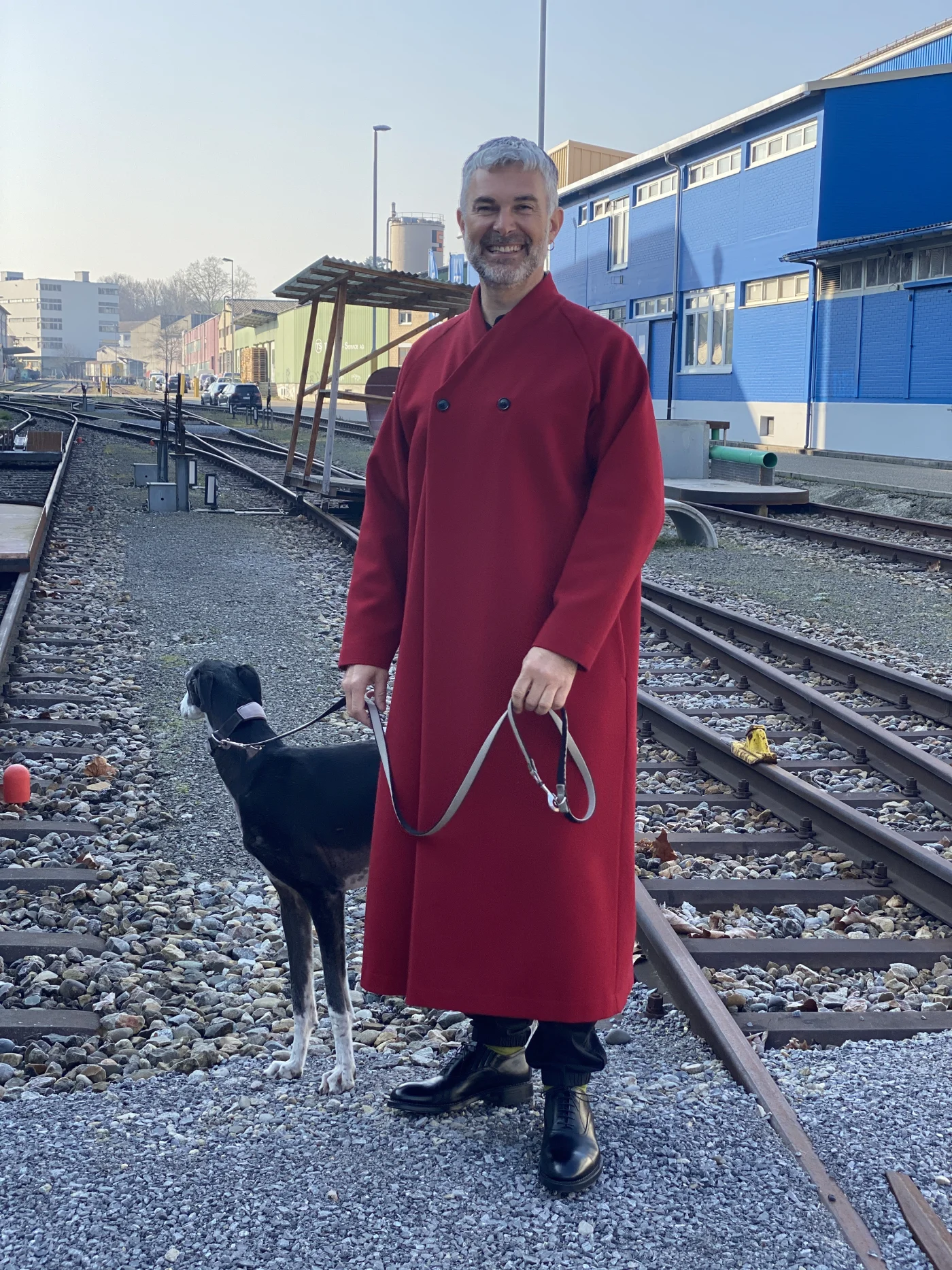 Dominik Bachmann in his deep-red gown – with his dog outside his atelier in Basel’s Dreispitz. Photo: Dörte Welti
