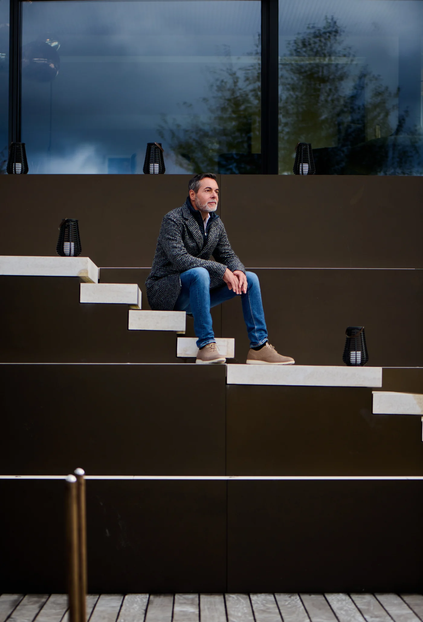 The maker on the staircase sculpture in front of his villa at dusk. Photo: Jean-Pierre Ritler