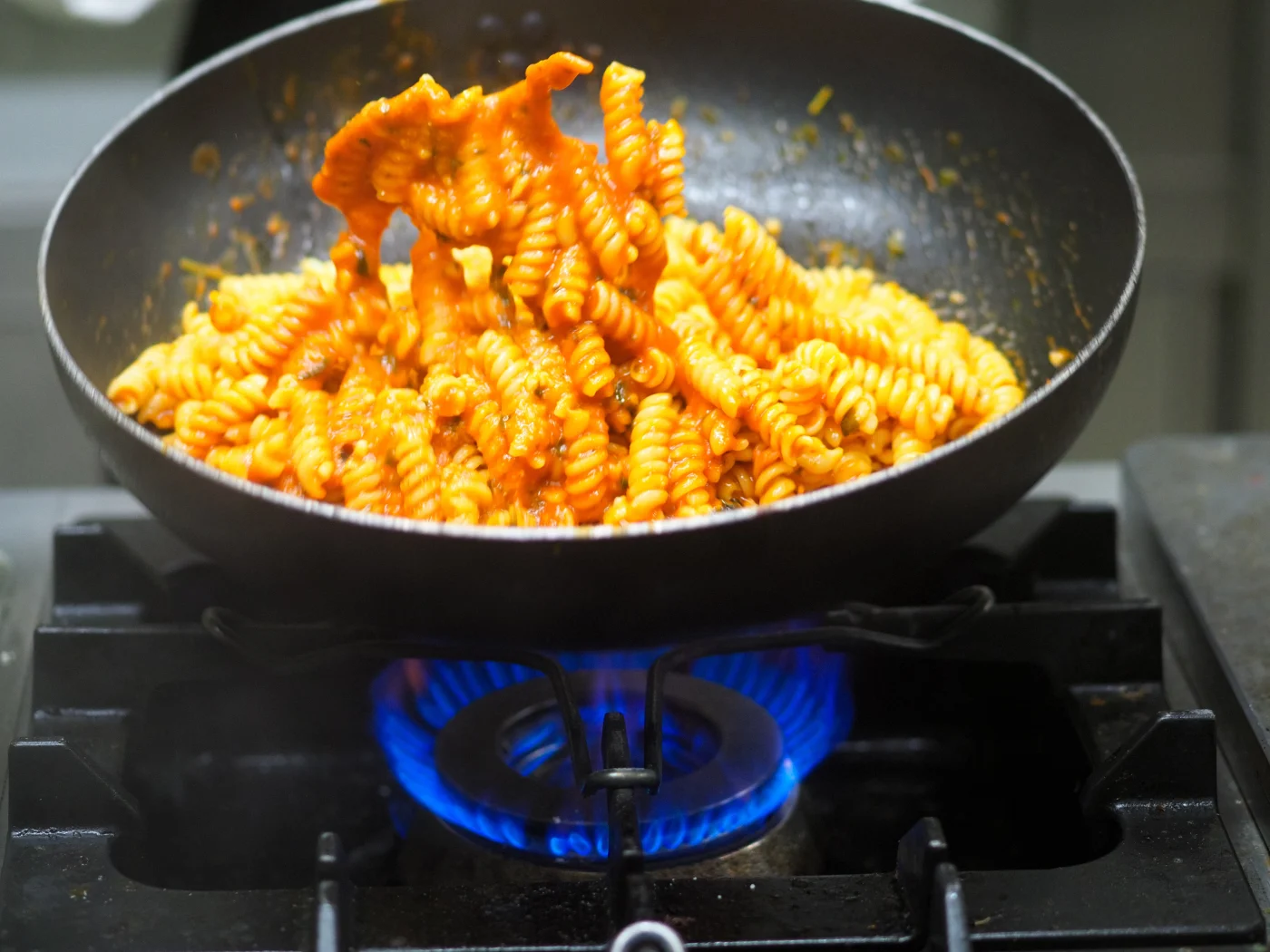The sound of love: pasta and sauce tossed together in the pan – a little pasta water makes the sauce creamy. Photo: Adobe Stock